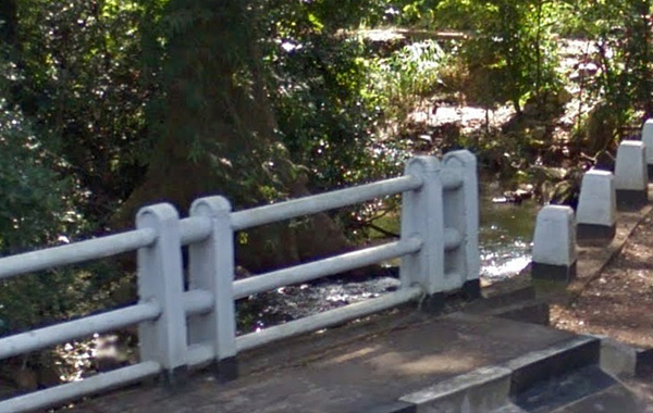 Скриншот с Google-карты на мосту дороги Matale-Dambulla (Столб 56/5 км) на январь 2016 года. На изображении отчетливо виден поток воды в русле ручья. Водная поверхность блестит на солнце.