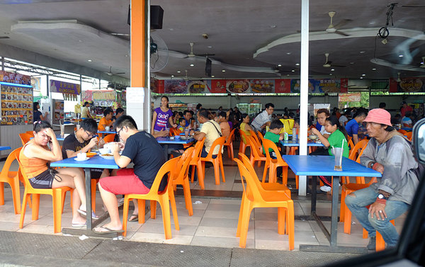 Типичная уличная малайзийская кафешка с пластиковыми столами и стульями